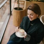 Young woman enjoying coffee in a cozy coffee shop.